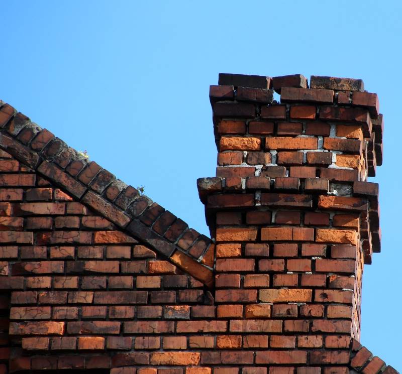 Damaged chimney on an White Settlement home showing cracks and missing mortar